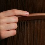 Woman combing her long hair, checking for hair thinning